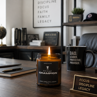 Candle labeled 'Champion' on a desk with motivational decor
